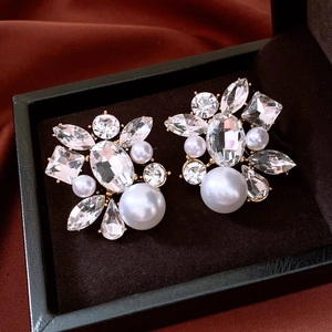 Macro shot of silver drop pearl earrings with crystals in a luxury jewelry box