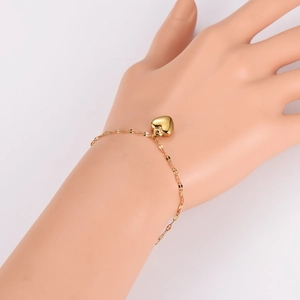Minimalist gold heart pendant bracelet for women displayed on a jewelry hand model