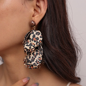 Close-up of leopard print chiffon petal tassel earrings worn by a female model