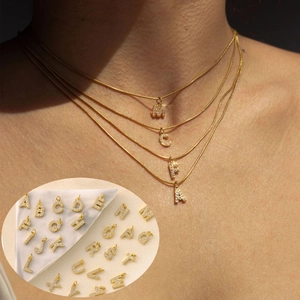 Detailed view of the 26 gold micro-pave zircon letters on fine necklaces and earrings