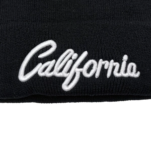 Black knit beanie with white California embroidery in cursive style for winter warmth
