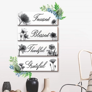 Detail of four wooden wall plaques with floral sketches and inspirational words