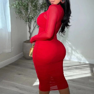 Détail de la robe en maille rouge froncée montrant la coupe moulante et le plissage