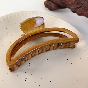 Detail of a French vintage tortoiseshell hair claw clip on a ceramic plate