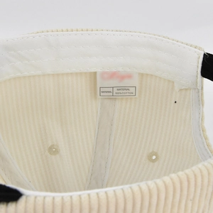 Macro view of corduroy baseball cap interior showing 100% cotton lining and stitching