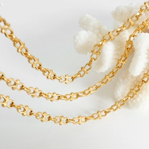 Gold plated titanium steel geometric chain link jewelry set on elegant white background