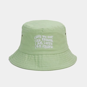 Détail de la broderie inspirante sur le chapeau bob en toile vert clair