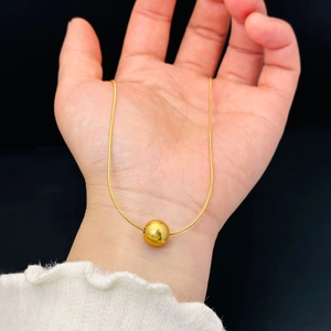 Minimalist gold round bead pendant necklace with sleek snake chain shown on hand
