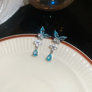 Dettaglio orecchini a farfalla in argento con gemme blu e accenti di zircone lucidi