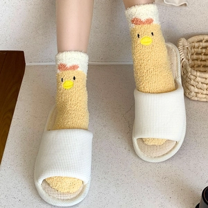 Detail of yellow coral fleece socks with cute cartoon chick design and wavy red edges
