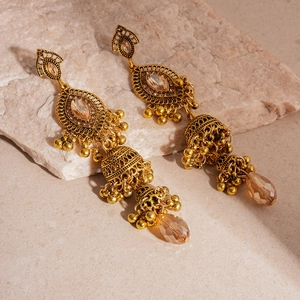 Detailed macro of vintage Jhumka earrings with champagne crystals and golden tassels