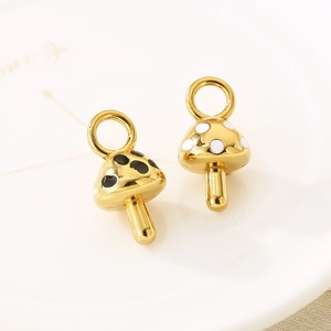 Close-up of 18K gold plated mushroom charms with black and white enamel dots detail