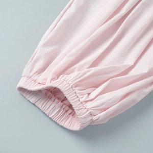 Detail of light pink cotton pants featuring elasticated cuffs and high-quality stitching