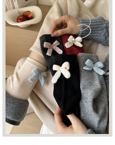 Detail showing wool blend socks with knitted bow accents in various autumn colors
