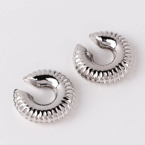 Close-up of silver-plated C-shaped ear clips with vintage twisted thread texture