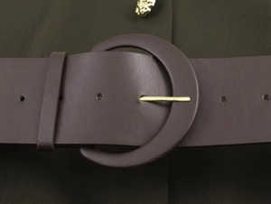 Close-up of a wide dark brown leather belt with a gold metal round buckle on a green dress
