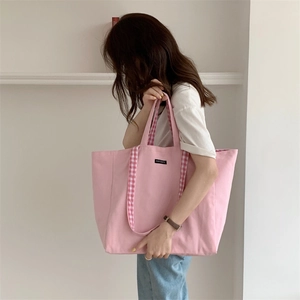 Pink canvas tote bag featuring stylish plaid handles and Merci Paris label detail