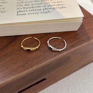 Detail of vintage adjustable silver and gold rings with black enamel and zircons