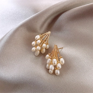 Elegant gold cluster earrings featuring teardrop pearls on a champagne silk background