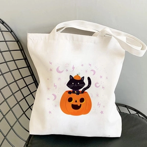 Détail d'un sac cabas en toile avec imprimé Halloween chat noir et citrouille sur une chaise