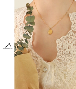 Close-up of 18K gold plated stainless steel necklace with irregular oval pendant