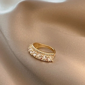 Retro gold butterfly ring with zircons on champagne silk background texture