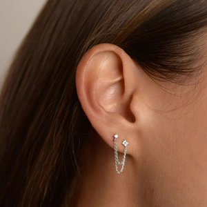 Close-up of double chain tassel earrings with silver finish and sparkling zirconia studs