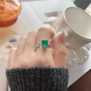 Close-up of S925 silver ring featuring emerald cut green zircon and crystal accents