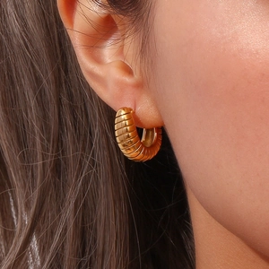 Close-up of elegant 18K gold plated ribbed hoop earrings worn by a model