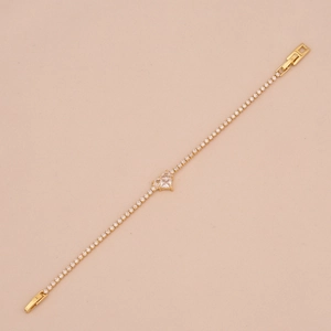 Macro detail of 18K gold-plated tennis bracelet with sparkling zircon heart-shaped centerpiece