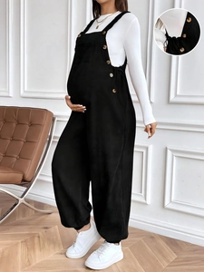 Detail of loose black corduroy maternity overalls with adjustable waist for pregnancy