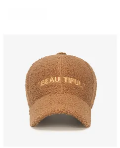 Detail showing the brown faux shearling texture and beautiful golden letter embroidery