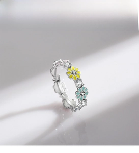 Close-up of 925 silver flower ring with colorful enamel daisies and sparkling zircons