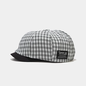 Close-up of black and white checkered newsboy cap with high-quality fabric texture