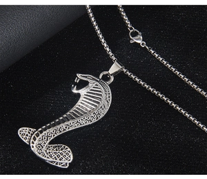 Détail macro du pendentif cobra en acier inoxydable texturé sur une chaîne box argent