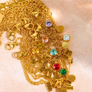 Gold zodiac birthstone necklaces with colorful zircon pendants on light pink surface