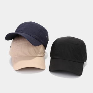 Detail of five-panel outdoor caps in navy, beige, and black with metal side vents