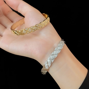 Detailed view of quilted pattern bangles with pavé zircon stones in gold and silver