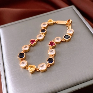Macro view of 18K gold-plated vintage bracelet with multi-colored square and heart gemstones
