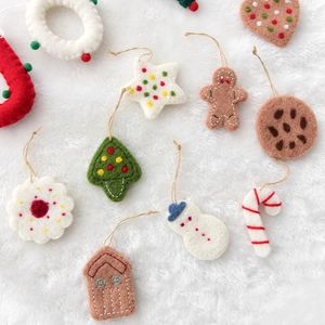 Handmade wool felt Christmas ornament set with snowmen and stars on soft white fur