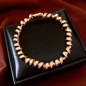 Detailed macro view of 18K gold plated twisted bracelet with pave set cubic zirconia stones