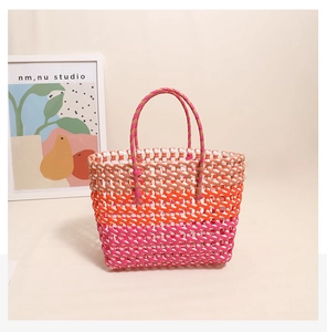 Detail showing the colorful woven gradient texture and sturdy dual handles of the beach bag