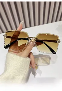 Close-up of rimless square sunglasses with luxury rhinestones and gold metal temples