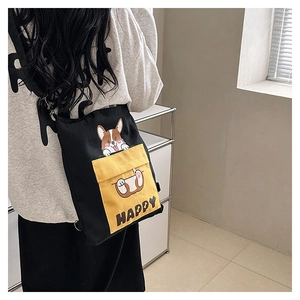 Detail of black canvas crossbody bag with yellow Corgi pocket and adjustable strap