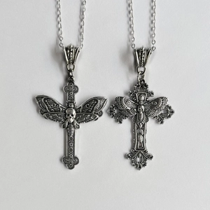 Gothic punk silver necklace featuring a cross, moth, and skull pendant on a gray background