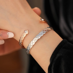 Détail de bracelets jonc or rose et argent avec texture losange et zircones