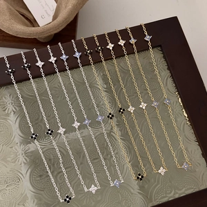 Four-leaf clover pendant necklaces in gold and silver finish with black and white inlay