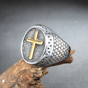 Vue macro de la bague en acier titane avec croix dorée et finition texturée