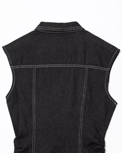 Rear view of black denim vest dress with white stitching and elastic waist detail