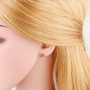 Close-up of pink zircon heart stud earrings in gold plating worn by model